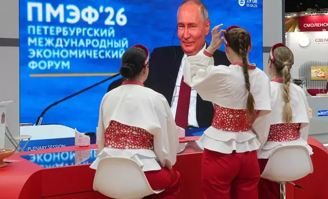 Participants watch a broadcast of Russian President Vladimir Putin's speech on a TV screen during a plenary session of the St. Petersburg International Economic Forum in St. Petersburg, Russia, Friday, June 5, 2026. (AP Photo/Dmitri Lovetsky)