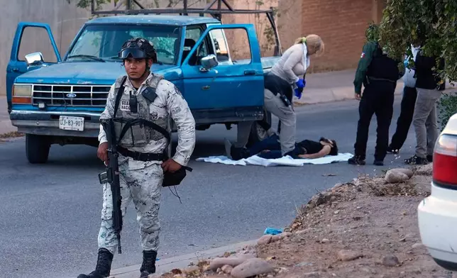 FILE - A National Guardsman stands guard as forensic experts inspect the site where the body of a victim of a fatal armed attack was found in Culiacán, Sinaloa state, Mexico, April 26, 2026. (AP Photo/Marco Ugarte, File)