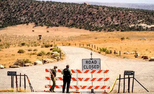 Law enforcement officers staff a roadblock as the Snyder Fire burns near Mack, Colo., on Sunday, June 28, 2026. (AP Photo/Noah Berger)