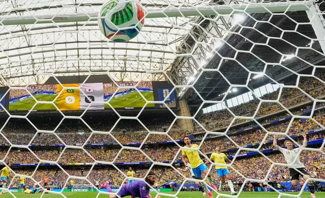 Japan's Kaishu Sano (24) scores their opening goal past Brazil goalkeeper Alisson Becker (1) during the World Cup round of 32 soccer match between Brazil and Japan in Houston, Monday, June 29, 2026. (AP Photo/Ashley Landis)