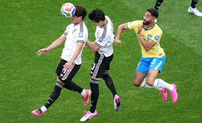 Japan's Keisuke Goto (9), left, and Japan's Shogo Taniguchi (3) head for the ball next to Brazil's Matheus Cunha (9) the World Cup round of 32 soccer match between Brazil and Japan in Houston, Monday, June 29, 2026. (AP Photo/Eric Smith)