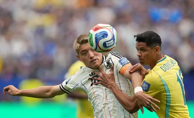 Japan's Ritsu Doan (10) cchallenges for the ball with with Brazil's Douglas Santos (16)during the World Cup round of 32 soccer match between Brazil and Japan in Houston, on Monday, June 29, 2026. (AP Photo/Eric Gay)