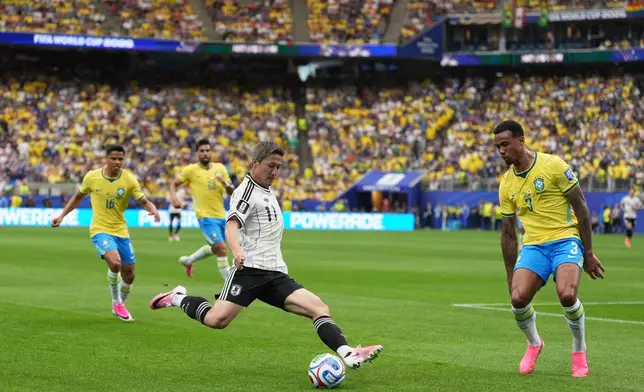 Japan's Daizen Maeda (11) tries to score next to Brazil's Gabriel Magalhaes (3) during the World Cup round of 32 soccer match between Brazil and Japan in Houston, on Monday, June 29, 2026. (AP Photo/Eric Gay)