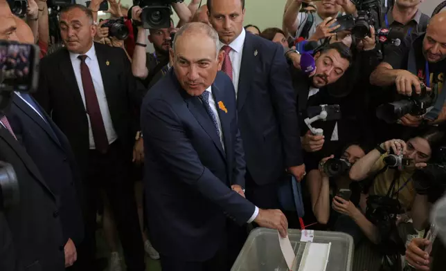 Armenian Prime Minister Nikol Pashinyan, center, casts his ballot at a polling station during the parliamentary election in Yerevan, Armenia, Sunday, June 7, 2026. (AP Photo/Anthony Pizzoferrato)