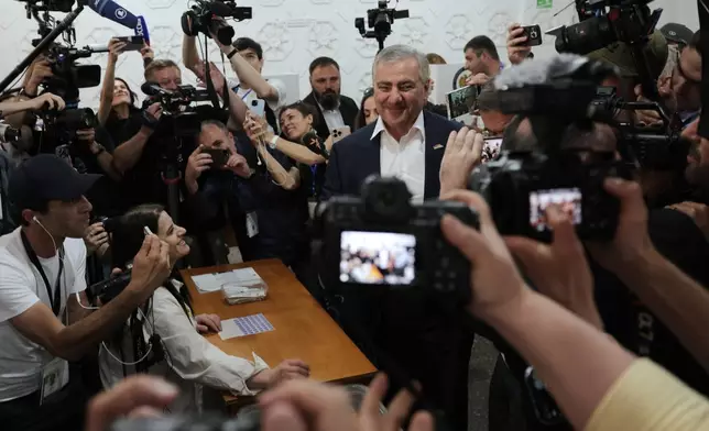 Russian-Armenian tycoon Samvel Karapetyan, center, speaks to the media after voting at a polling station during parliamentary election in Yerevan, Armenia, Sunday, June 7, 2026. (AP Photo/Anthony Pizzoferrato)