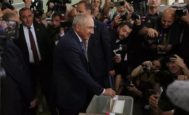 Armenian Prime Minister Nikol Pashinyan, center, casts his ballot at a polling station during the parliamentary election in Yerevan, Armenia, Sunday, June 7, 2026. (AP Photo/Anthony Pizzoferrato)