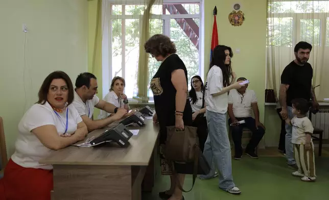 Voters gather to get their ballots at a polling station during the parliamentary election in Yerevan, Armenia, Sunday, June 7, 2026. (AP Photo/Anthony Pizzoferrato)