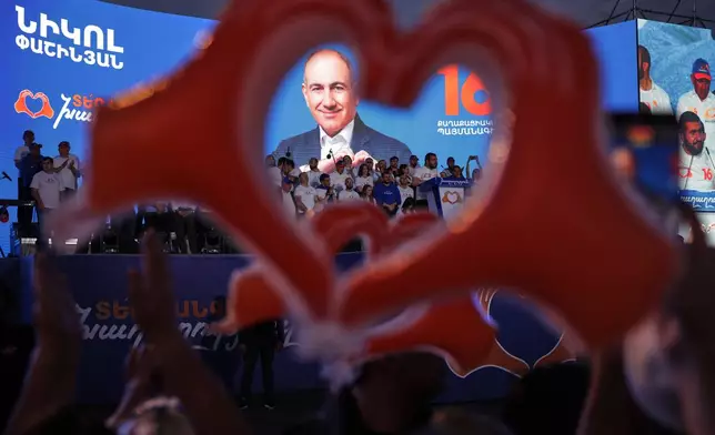 Supporters of Armenia's ruling Civil Contract party leading by Prime Minister Nikol Pashinyan hold up heart signs while gathering in Republic Square in Yerevan, Armenia, Friday, June 5, 2026, for the party's final campaign rally ahead of the upcoming parliamentary elections. (AP Photo/Anthony Pizzoferrato)