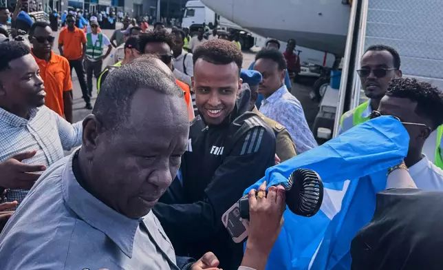 Referee Omar Artan, center, who was denied entry to the United States, is welcomed by supporters upon his arrival in Mogadishu, Somalia, Wednesday, June 10, 2026. (AP Photo/Farah Abdi Warsameh)
