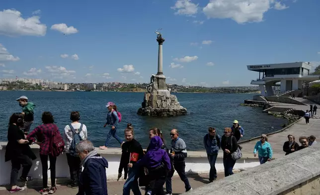 FILE - Tourists walk along an embankment in Sevastopol, Crimea, Monday, May 2, 2022. (AP Photo, File)
