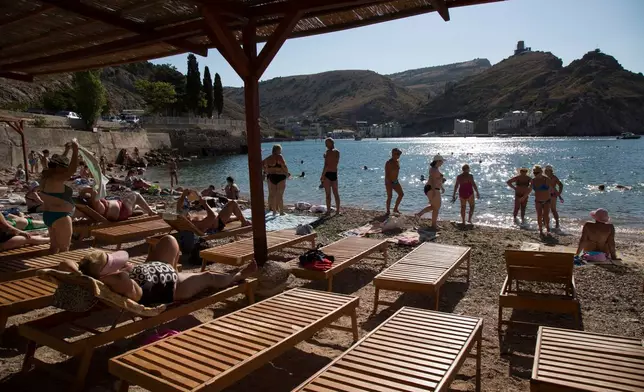 FILE - People gather at the beach in Balaklava Bay, a part of Sevastopol on the Crimean Peninsula, on Sunday, Aug. 9, 2015. (AP Photo/Alexander Zemlianichenko, File)