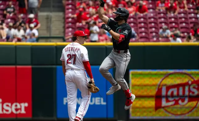Arizona Diamondbacks Tommy Troy, right, celebrates after hitting a home run in the third inning of a baseball game against the Cincinnati Reds, Sunday, June 14, 2026, in Cincinnati. (AP Photo/Michael Swensen)