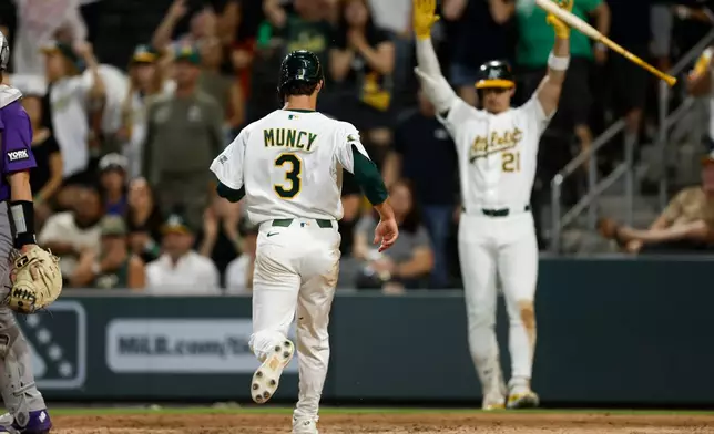 Athletics' Max Muncy (3), scores on a single by Lawrence Butler (4) during the eighth inning of a baseball game against the Colorado Rockies, Friday, June 12, 2026, in Las Vegas. (AP Photo/Caroline Brehman)