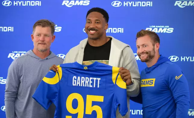 From left, Los Angeles Rams general manager Les Snead, left, defensive end Myles Garrett, and head coach Sean McVay pose for a photo during a press conference following the NFL football team's practice, Tuesday, June 2, 2026, in Woodland Hills, Calif. (AP Photo/Kyusung Gong)