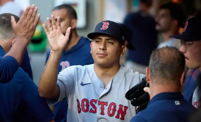 Boston Red Sox starting pitcher Ranger Suarez is greeted in the dugout after leaving during the seventh inning against the Seattle Mariners of a baseball game, Friday, June 19, 2026, in Seattle. (AP Photo/John Froschauer)