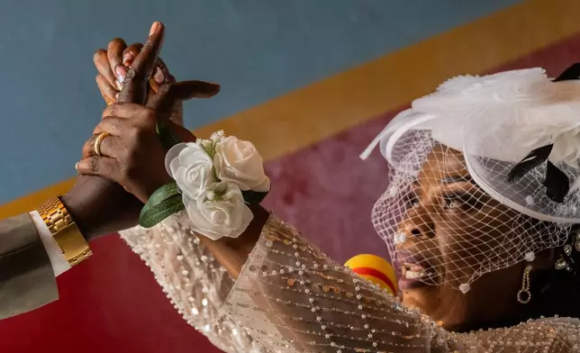 A bride puts a ring on the groom's finger during a wedding ceremony amid an Ebola outbreak in Ituri Province in Bunia, Congo, Saturday, June 6, 2026. (AP Photo/Moses Sawasawa)