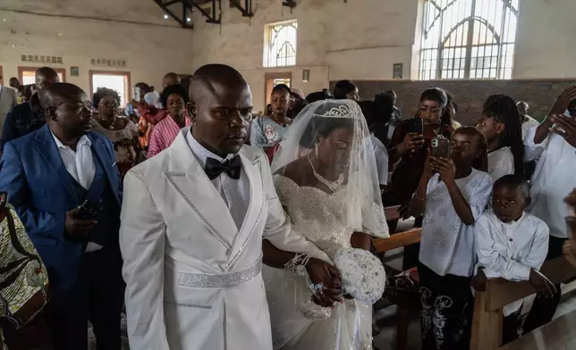 A newly married couple walks down the aisle at their wedding amid an Ebola outbreak in Ituri Province in Bunia, Congo, Saturday, June 6, 2026. (AP Photo/Moses Sawasawa)