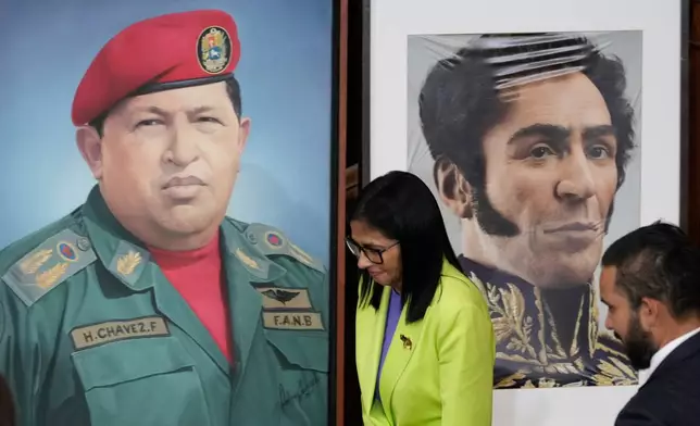 FILE - Venezuela's acting President Delcy Rodriguez walks past a image of former President Hugo Chavez, left, and Independence hero Simon Bolivar at the National Assembly in Caracas, Venezuela, Jan. 15, 2026. (AP Photo/Ariana Cubillos, File)