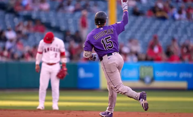 Colorado Rockies' Hunter Goodman, right, gestures as he rounds second while Los Angeles Angels shortstop Oswald Peraza stands by during the second inning of a baseball game Tuesday, June 2, 2026, in Anaheim, Calif. (AP Photo/Mark J. Terrill)