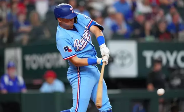 Texas Rangers' Josh Jung connects for a bases loaded single to score Kyle Higashioka and Nicky Lopez during the fourth inning of a baseball game Sunday, May 31, 2026, in Arlington. (AP Photo/Julio Cortez)