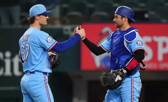 Texas Rangers pitcher Jacob Latz, left, and catcher Kyle Higashioka (11) react after their team defeated the Kansas City Royals during a baseball game Sunday, May 31, 2026, in Arlington. (AP Photo/Julio Cortez)