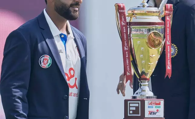 Afghanistan's captain Hashmatullah Shahidi, left, and India's captain Shubman Gill walk after posing with the winners' trophy before the start of play on day one of the cricket test match between Afghanistan and India in New Chandigarh, India, Saturday, June 6, 2026. (AP Photo/Ashwini Bhatia)