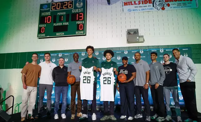 First round NBA draft picks of the Milwaukee Bucks, Nate Ament, fifth from left and Brayden Burries pose for a photograph at a Boys and Girls club in Milwaukee, Thursday, June 25, 2026. (AP Photo/Jeffrey Phelps)