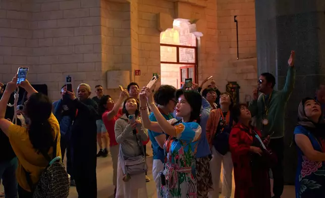 Visitors take photos inside Antoni Gaudí's Basilica of the Sagrada Familia in Barcelona, Spain, Tuesday, May 26, 2026, ahead of Pope Leo XIV's visit to the city in June. (AP Photo/Emilio Morenatti)
