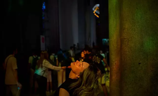 A visitor looks up inside Antoni Gaudí's Basilica of the Sagrada Familia as colored light from its stained-glass windows illuminates the interior in Barcelona, Spain, Tuesday, May 26, 2026, ahead of Pope Leo XIV's visit to the city in June. (AP Photo/Emilio Morenatti)