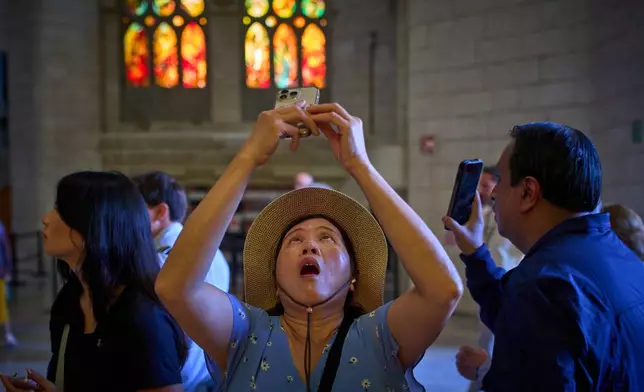 Visitors take photos inside Antoni Gaudí's Basilica of the Sagrada Familia in Barcelona, Spain, Tuesday, May 26, 2026, ahead of Pope Leo XIV's visit to the city in June. (AP Photo/Emilio Morenatti)