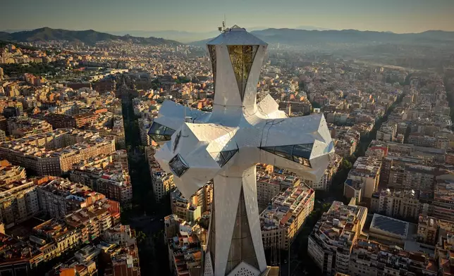 The cross crowns the 172.5-meter (566-foot) Tower of Jesus Christ at the Sagrada Familia basilica in Barcelona, Spain, Thursday, May 28, 2026, ahead of Pope Leo XIV's visit to the city in June. (AP Photo/Emilio Morenatti)