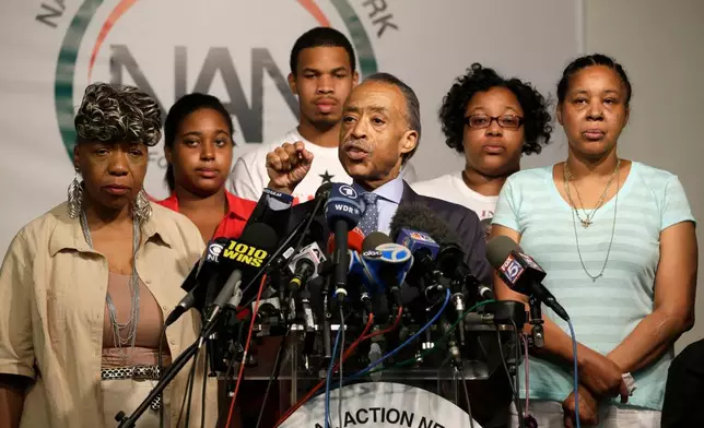 FILE - The Rev. Al Sharpton, center, is joined by Eric Garner's mother Gwen Carr, left, daughter Erica Garner, second from left, son Eric Garner, third from left, daughter Emerald Snipes, second from right, and wife Esaw Snipes, as he speaks during a news conference, Tuesday, July 14, 2015, in New York. (AP Photo/Mary Altaffer, File)