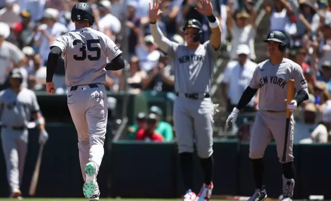 New York Yankees' Cody Bellinger (35) heads toward teammates after scoring during the third inning of a baseball game against the Athletics, Sunday, May 31, 2026, in West Sacramento, Calif. (AP Photo/Scott Marshall)