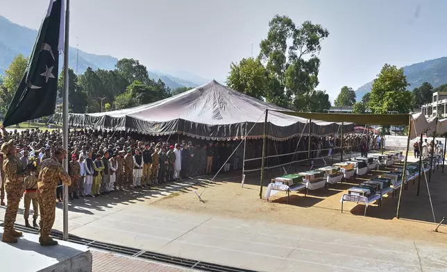 Military officers and civilians attend the funeral prayers of military personnel, killed in Wednesday's helicopter crash, during a funeral prayer, in Muzaffarabad, the capital of Pakistan-administered Kashmir, Thursday, June 11, 2026. (AP Photo/M.D. Mughal)
