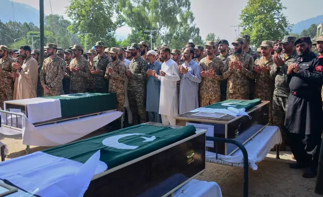 Military officers and civilians attend the funeral prayers of military personnel, killed in Wednesday's helicopter crash, during a funeral prayer, in Muzaffarabad, the capital of Pakistan-administered Kashmir, Thursday, June 11, 2026. (AP Photo/M.D. Mughal)