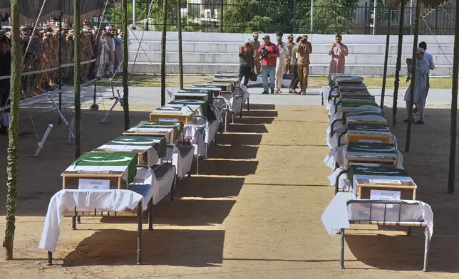 Military officers and civilians attend the funeral prayers of military personnel, killed in Wednesday's helicopter crash, during a funeral prayer, in Muzaffarabad, the capital of Pakistan-administered Kashmir, Thursday, June 11, 2026. (AP Photo/M.D. Mughal)