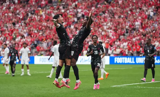 Canada's Jonathan David, front right, celebrates with Stephen Eustaquio,left, after scoring a goal during World Cup Group B soccer match between Canada and Qatar in Vancouver, British Columbia, Thursday, June 18, 2026. (Darryl Dyck/The Canadian Press via AP)