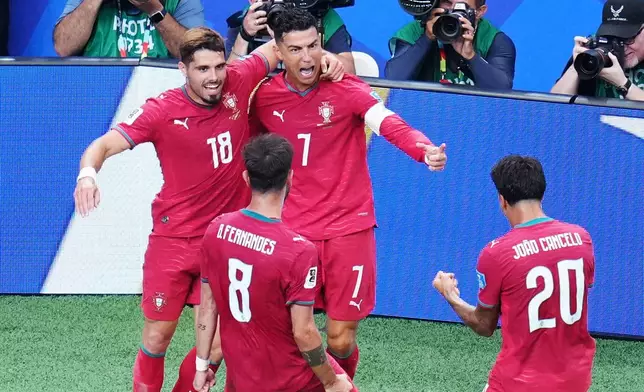 Portugal's Cristiano Ronaldo (7) celebrates with Portugal's Pedro Neto (18), Portugal's Bruno Fernandes (8) and Portugal's Joao Cancelo (20) after scoring his side's third goal during the World Cup Group K soccer match between Portugal and Uzbekistan in Houston, Tuesday, June 23, 2026. (AP Photo/Karen Warren)
