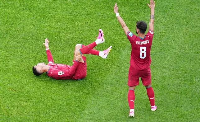 Portugal's Cristiano Ronaldo (7) reacts on the ground near Portugal's Bruno Fernandes (8) during the World Cup Group K soccer match between Portugal and Uzbekistan in Houston, Tuesday, June 23, 2026. (AP Photo/Karen Warren)