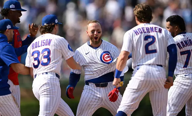Chicago Cubs' Michael Busch, center, celebrates with teammates after driving in the game-winning run with a single in the 10th inning of a baseball game to defeat the San Francisco Giants in Chicago, Saturday, June 6, 2026. (AP Photo/Paul Beaty)