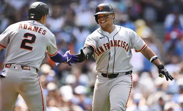 San Francisco Giants' Rafael Devers, right, celebrates with teammate Willy Adames (2) after hitting a solo home run during the sixth inning of a baseball game against the Chicago Cubs in Chicago, Saturday, June 6, 2026. (AP Photo/Paul Beaty)