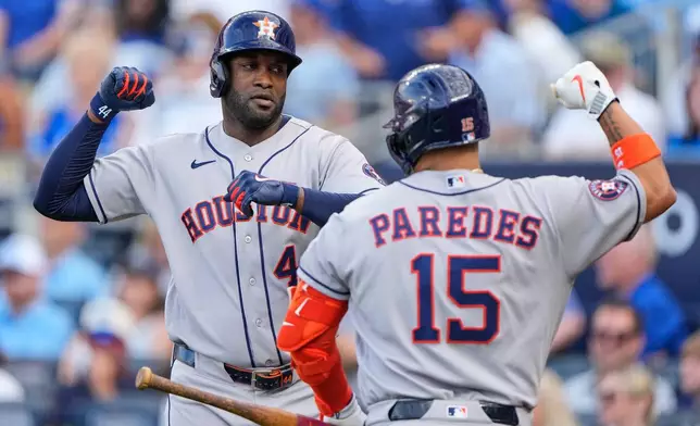 Houston Astros' Yordan Alvarez, left, celebrates with Isaac Paredes (15) after hitting a two-run home run during the first inning of a baseball game against the Kansas City Royals, Friday, June 12, 2026, in Kansas City, Mo. (AP Photo/Charlie Riedel)