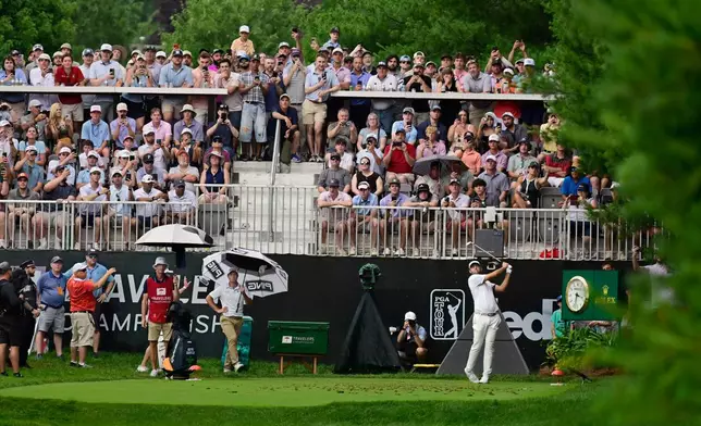 Scottie Scheffler, right, tees off the eighth hole during the third round of the Travelers Championship golf tournament at TPC River Highlands, Saturday, June 27, 2026, in Cromwell, Conn. (AP Photo/Jessica Hill)