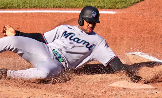 Miami Marlins' Xavier Edwards scores on a single by Heriberto Hernández off Pittsburgh Pirates pitcher Mason Montgomery during the sixth inning of a baseball game in Pittsburgh, Saturday, June 13, 2026. (AP Photo/Gene J. Puskar)