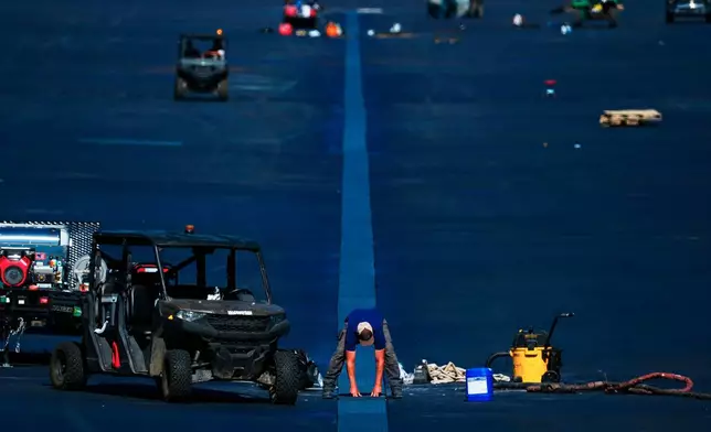 A worker places a grate in the center of the Lincoln Memorial Reflecting Pool as work continues, Wednesday, June 3, 2026 in Washington. (AP Photo/Julia Demaree Nikhinson)