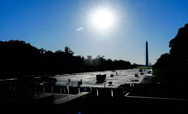 Work continues on the Lincoln Memorial Reflecting Pool after it was coated in a blue swimming pool surface ahead of the United States' 250th anniversary, Thursday, June 4, 2026, in Washington. (AP Photo/Julia Demaree Nikhinson)