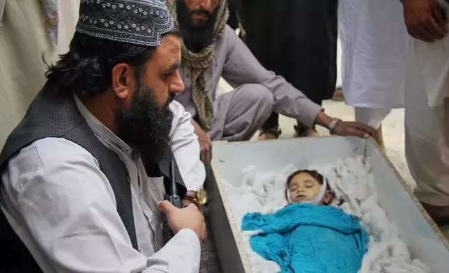 Residents mourn over the body of a child killed in airstrikes that Taliban officials said were carried out by Pakistan and killed civilians, including children, in Mana, a village in Afghanistan's Khost province, Wednesday, June 10, 2026. (AP Photo/Saifullah Zahir)