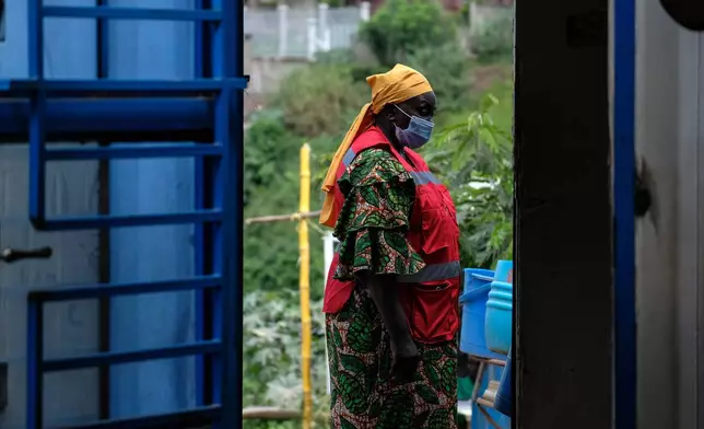 A health worker walks at a temporary health clinic at the Mpondwe border crossing linking Uganda and the Democratic Republic of the Congo, Thursday, June 4, 2026. (AP Photo/Hajarah Nalwadda)