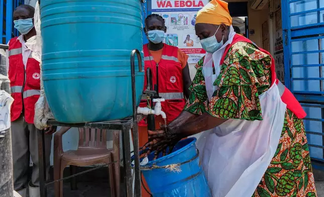 A health worker washes her hands at a temporary health clinic at the Mpondwe border crossing linking Uganda and the Democratic Republic of the Congo, Thursday, June 4, 2026. (AP Photo/Hajarah Nalwadda)