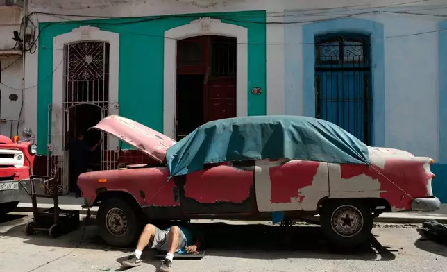 FILE - A man works on a classic American car in Havana, Cuba, June 17, 2026. (AP Photo/Jorge Luis Banos, File)